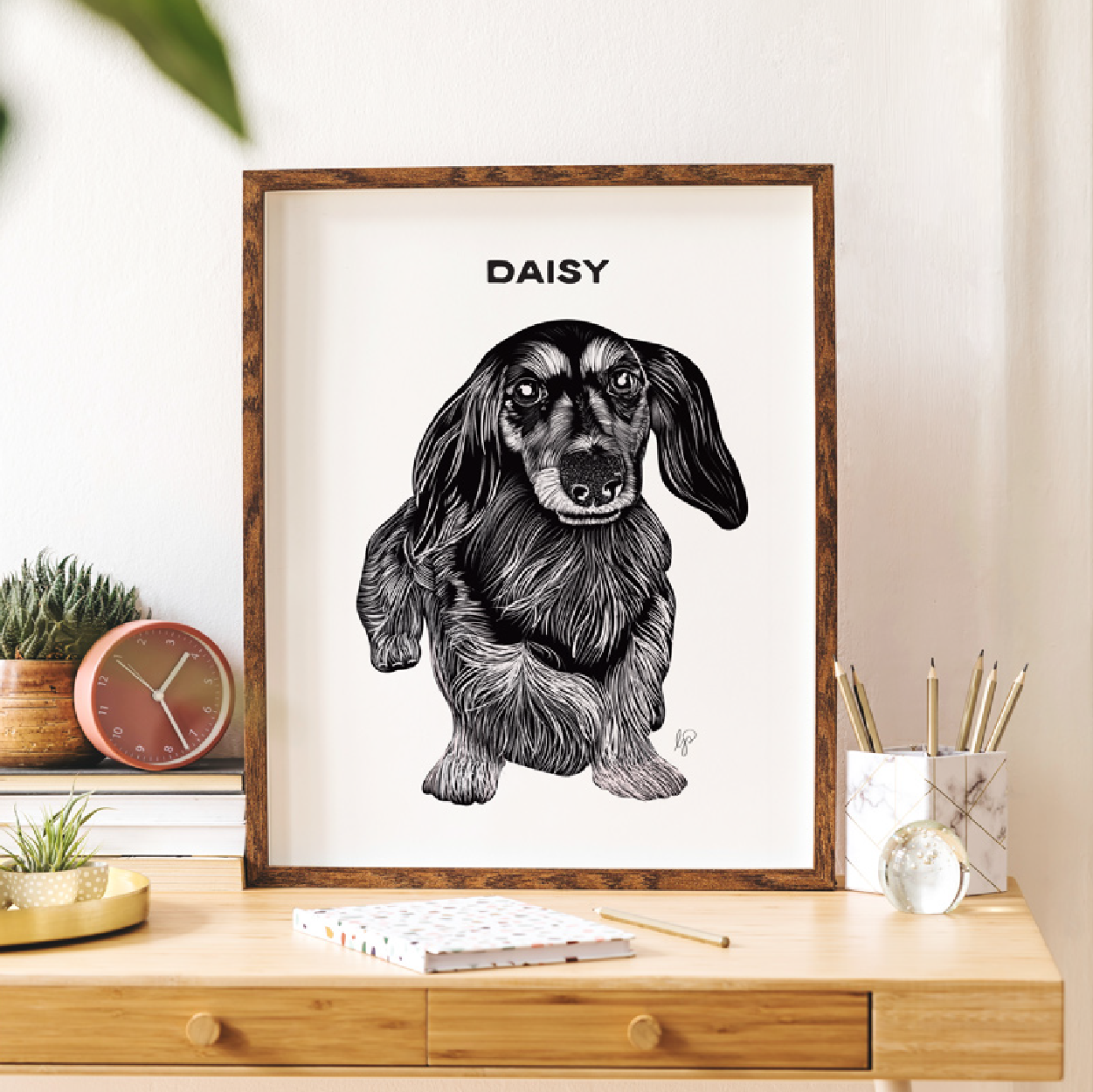 black and white illustrative portrait of a dachshund dog placed in a frame on a desk